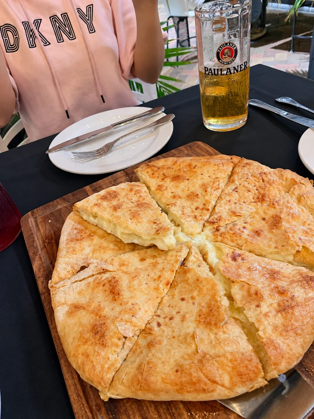 A round golden khachapuri cut into wedges with melted cheese between the layers