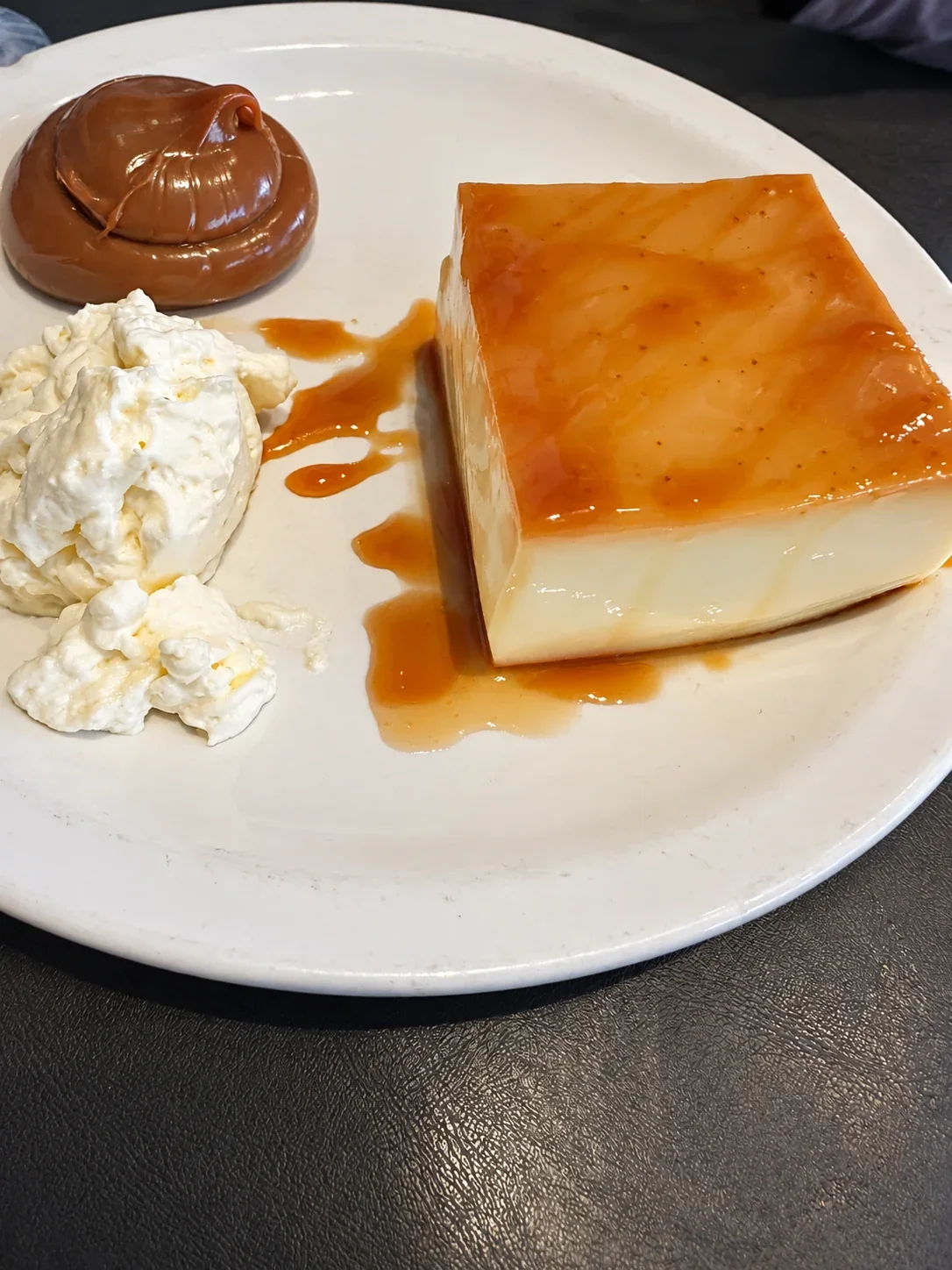 Caramel flan with dulce de leche and whipped cream at Bodegón Núñez