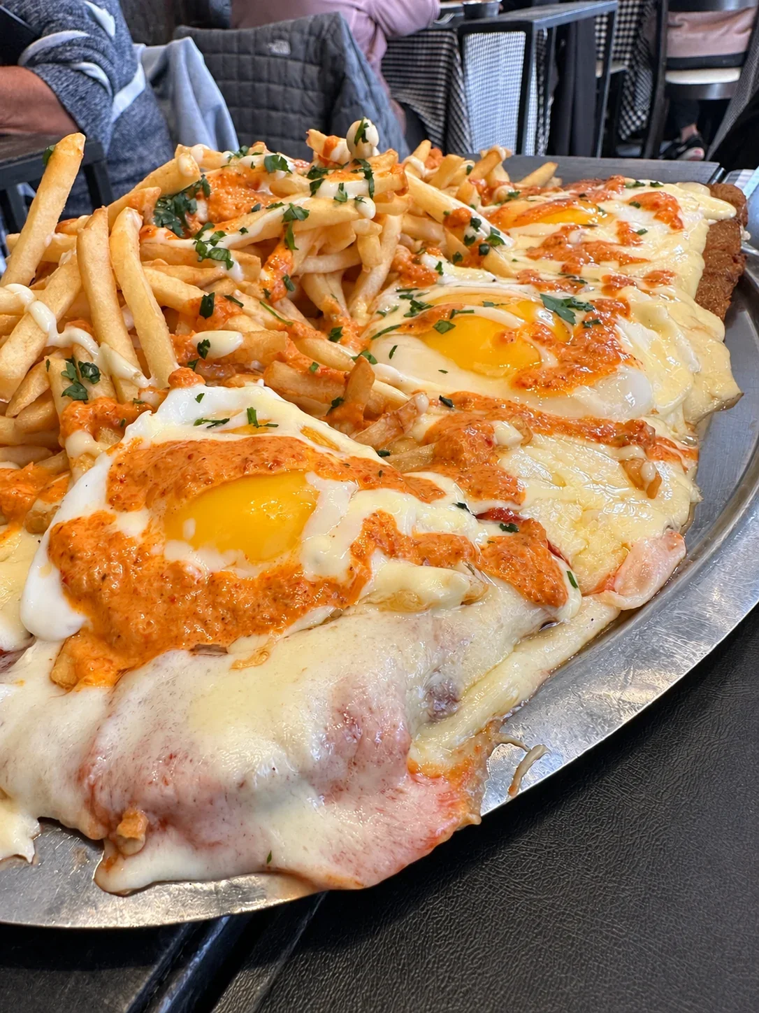 A closer view of the cheese and fried eggs on the Gran Bodegón milanesa