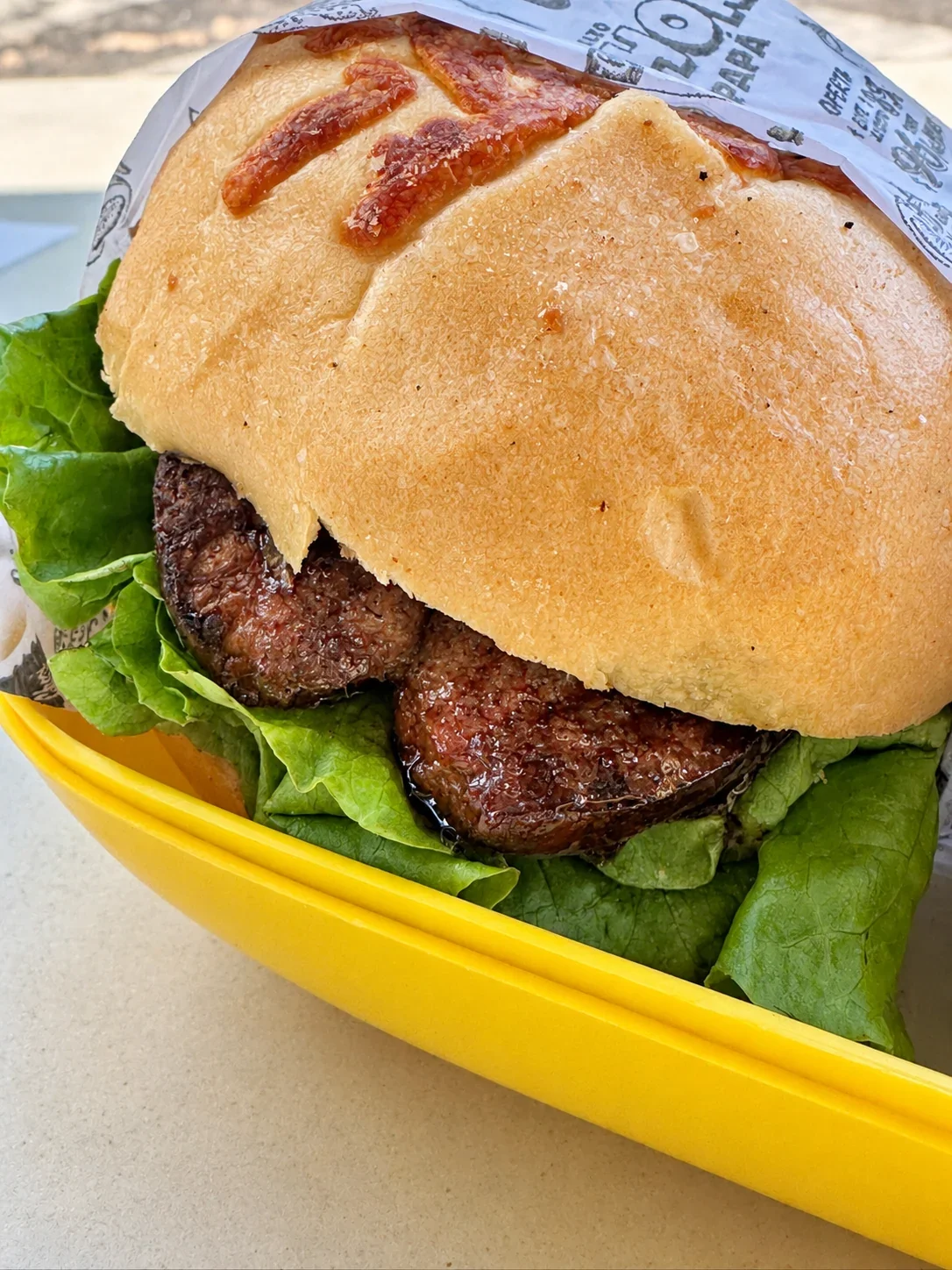 Chori’s smoked-pork sausage sandwich with lettuce in a cheese-topped roll, served in a yellow basket
