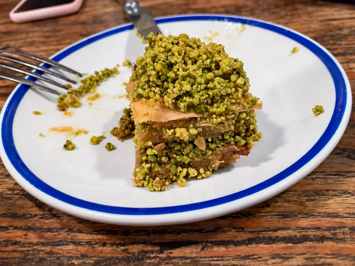 Layers of pistachio baklava on a blue-rimmed plate at Mandolin