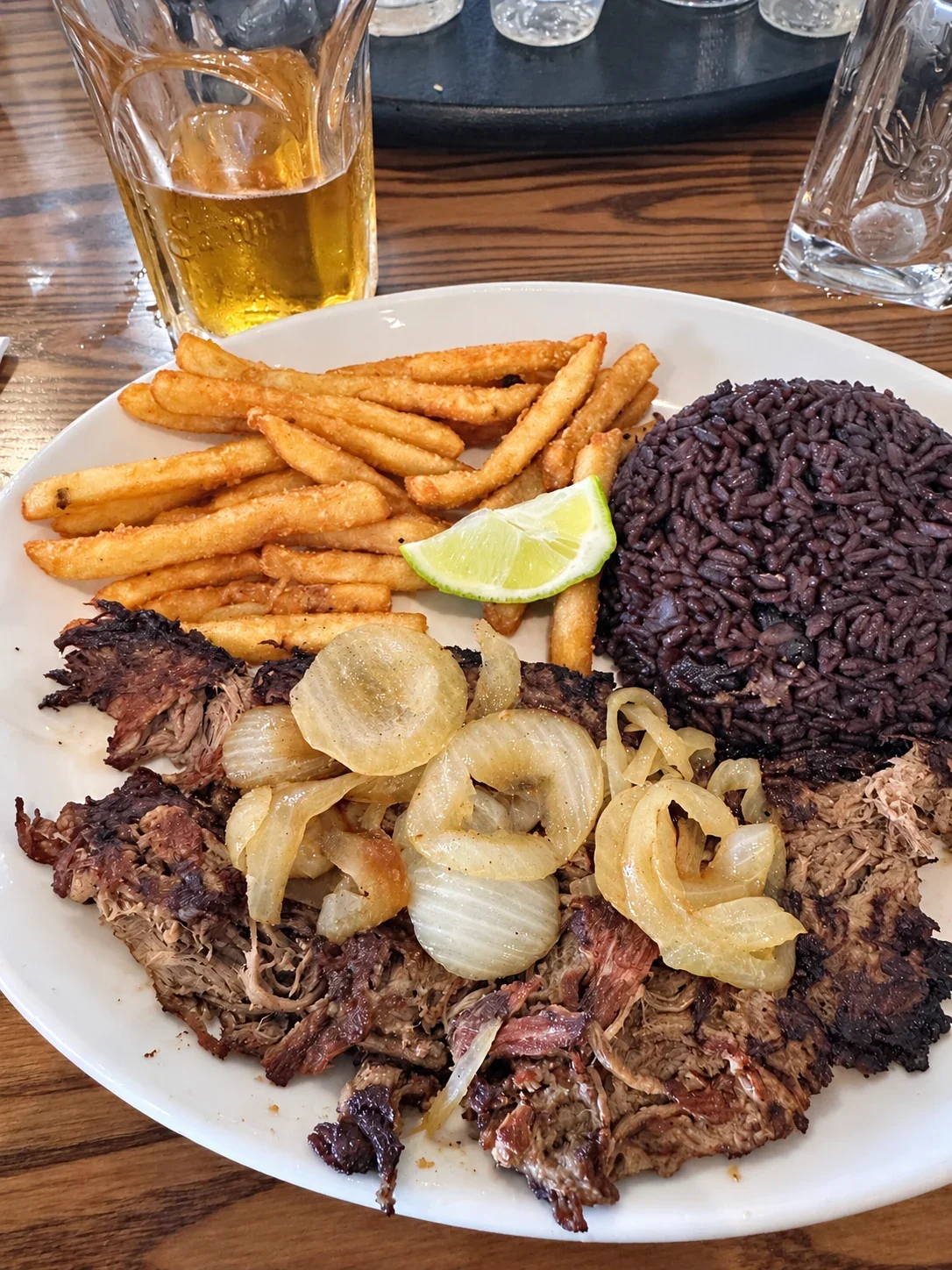 Vaca frita with onions, lime, fries and dark rice with black beans at Sergio’s London Square