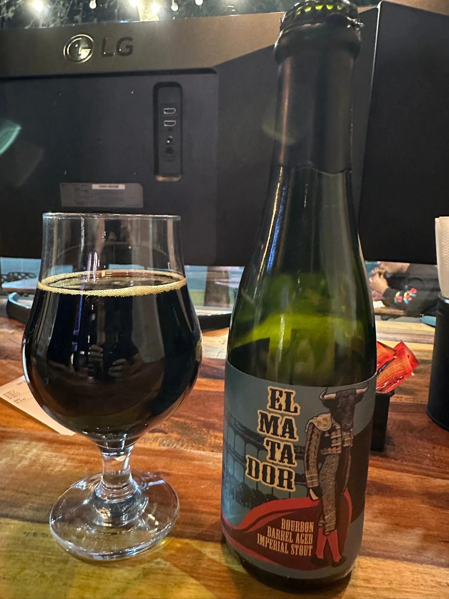 El Matador Bourbon Barrel Aged Imperial Stout bottle beside a glass of dark beer
