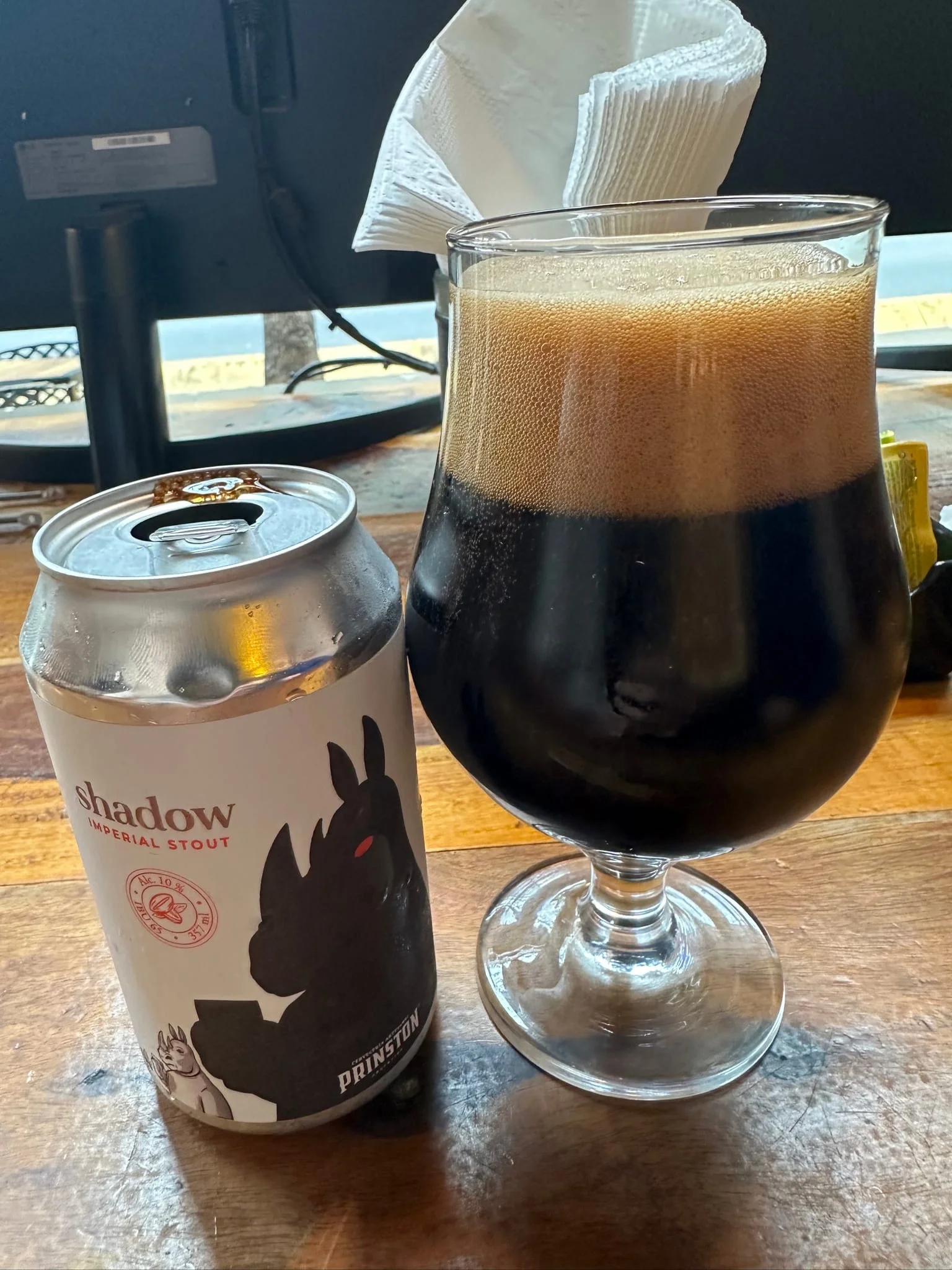 Prinston Shadow Imperial Stout can beside a glass of dark beer with a thick head
