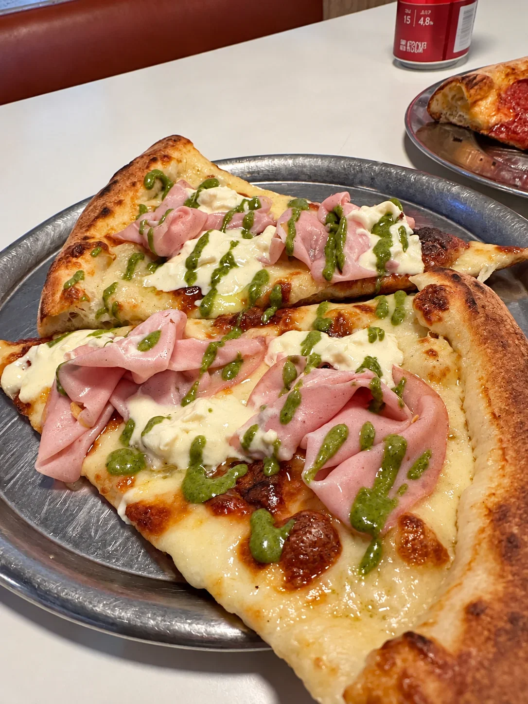 Mortadella, stracciatella and pesto on New York–style pizza slices at Togni’s in Belgrano
